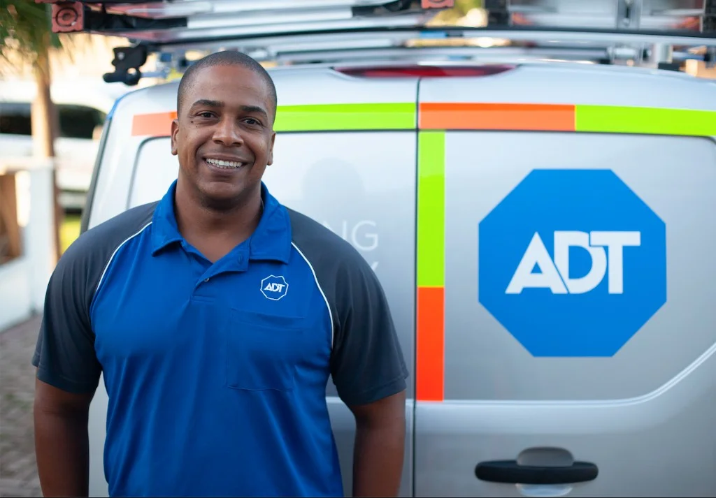 ADT technician standing in front of an ADT-branded service vehicle
